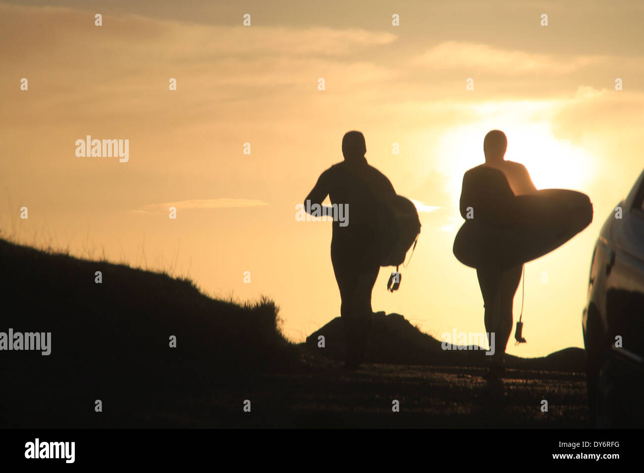 Silhouette von 2 Surfer zu Fuß in den Sonnenuntergang Stockfoto