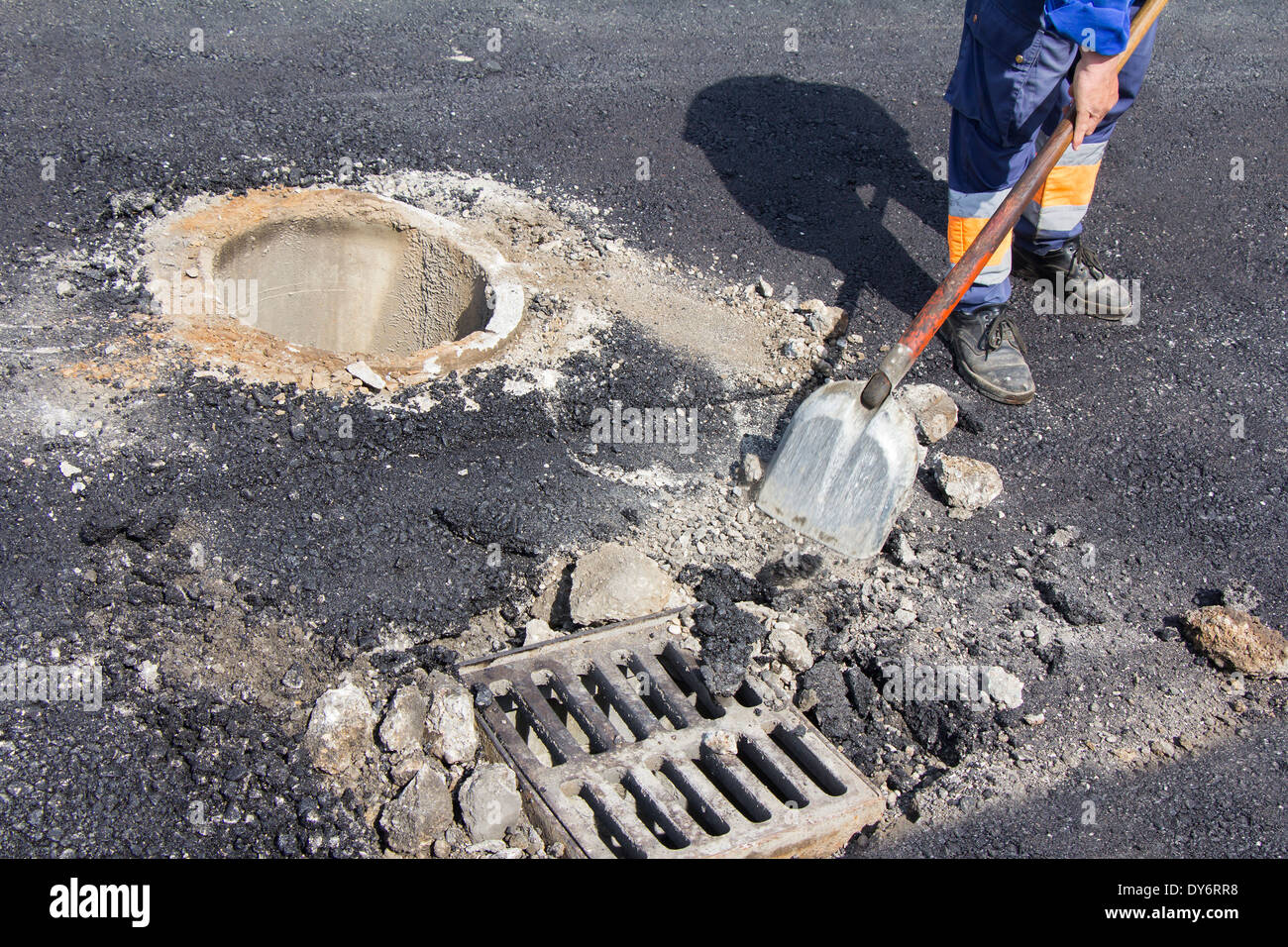 Dienstprogramme Arbeiter Kanalisation Kanaldeckel auf der Straße zu reparieren Stockfoto