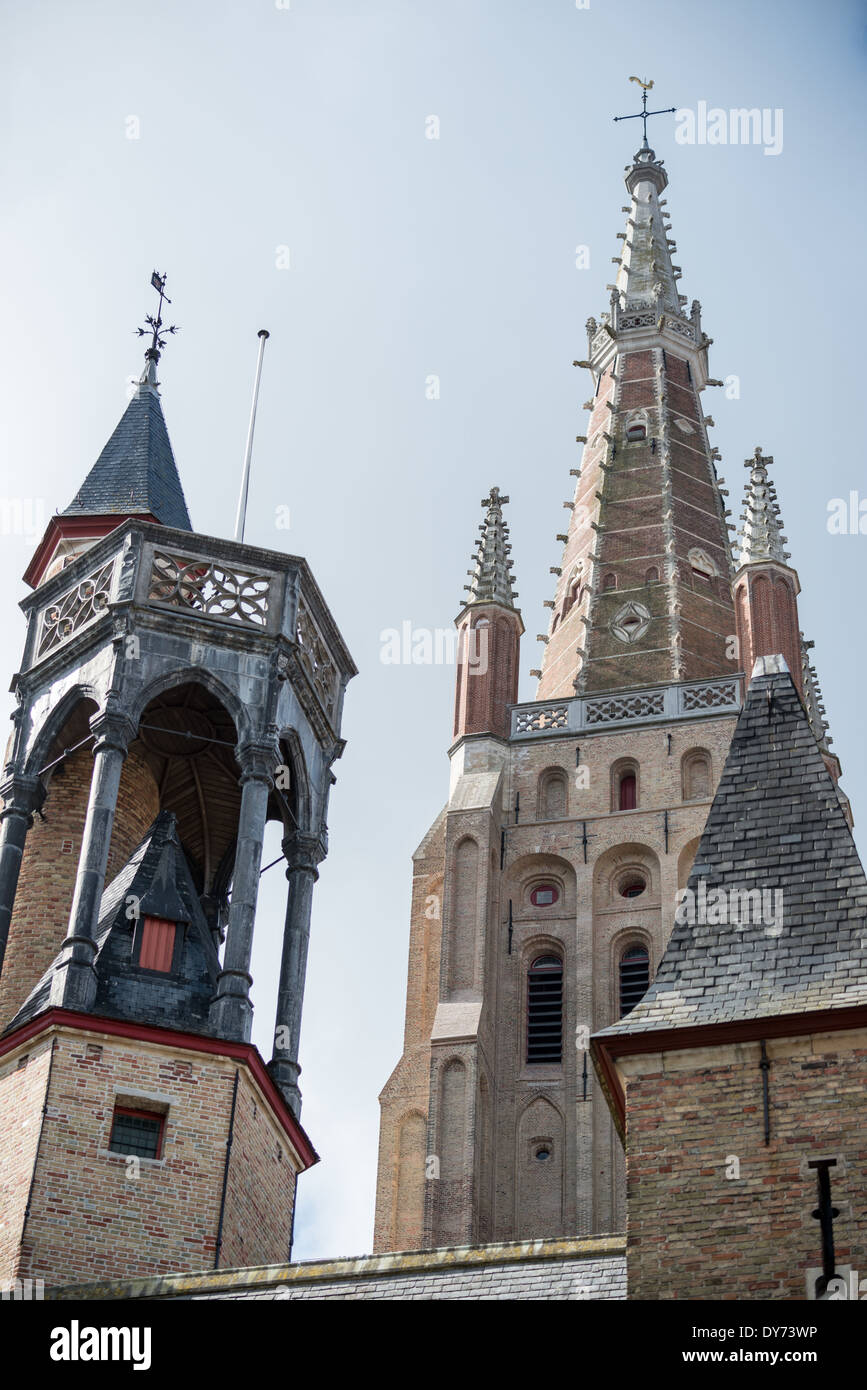 Kirche der Muttergottes Brügge Belgien // BRÜGGE, Belgien — der hoch aufragende gotische Turm der Muttergottes (Onze-Lieve-Vrouwekerk) dominiert die mittelalterliche Skyline von Brügge. Dieses architektonische Meisterwerk erhebt sich deutlich über dem historischen Zentrum und ist eines der bekanntesten Wahrzeichen der Stadt. Der Turm ist ein Beispiel für die anspruchsvolle Technik und künstlerische Leistung der mittelalterlichen gotischen Architektur. Stockfoto