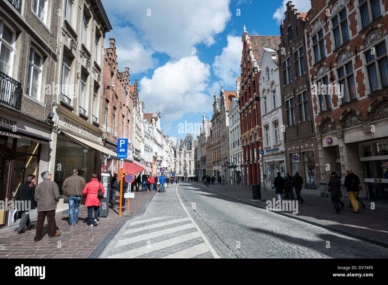 Kopfsteinpflasterstraße historische Architektur Brügge Belgien // BRÜGGE, Belgien — Eine kopfsteingepflasterte Straße im historischen Zentrum von Brügge zeigt traditionelle Architektur, die Einzelhandels- und Wohnräume kombiniert. Die erhaltene mittelalterliche Straßenlandschaft zeigt charakteristische flämische Gebäudefassaden und historische Ladenfronten. Dieses lebendige städtische Umfeld zeigt die anhaltende Vitalität der historischen Geschäftsstraßen Brügge. Stockfoto