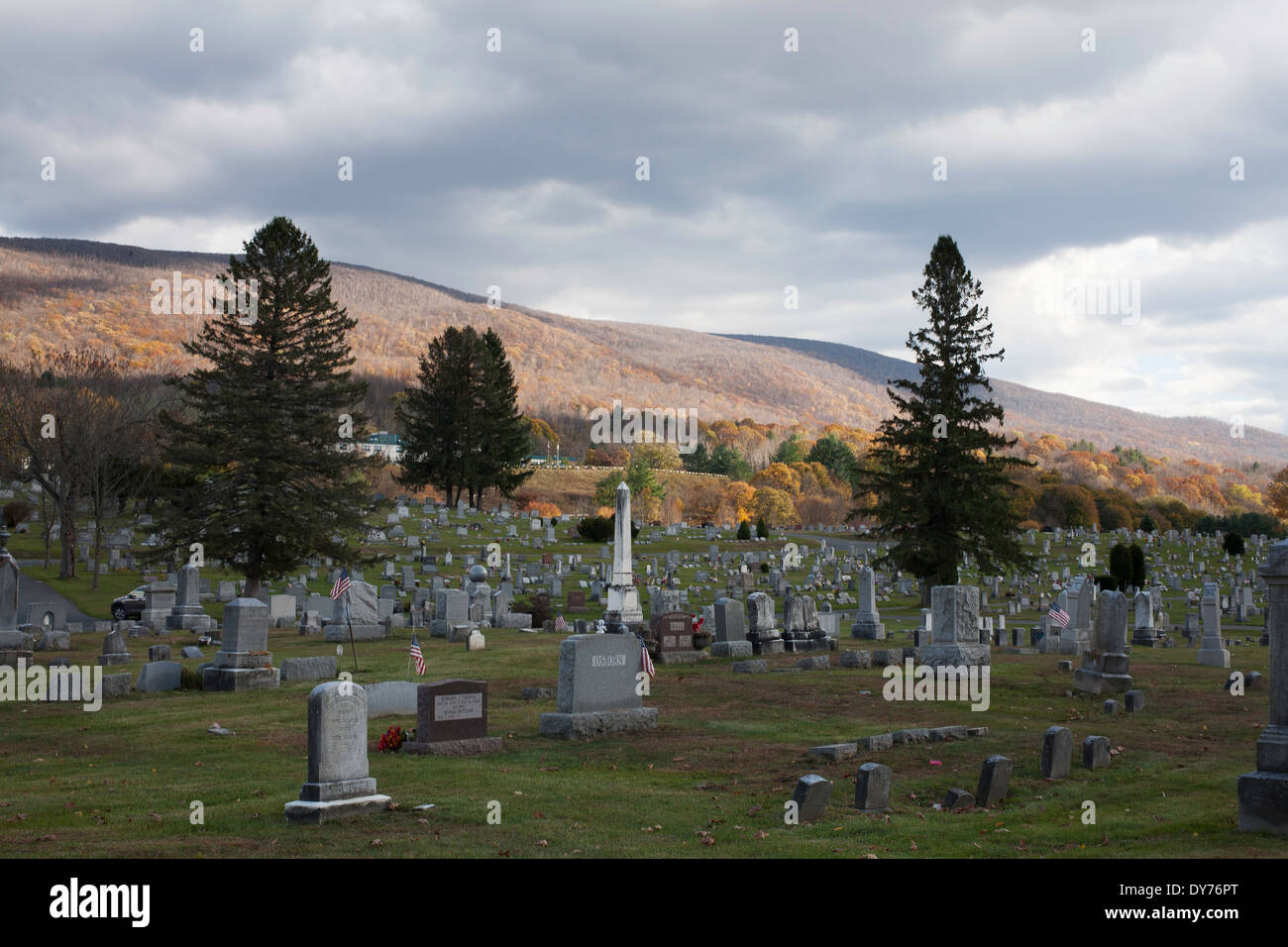 Ein Friedhof in North Adams, Massachusetts mit der untergehenden Sonne auf den Bergen. Stockfoto