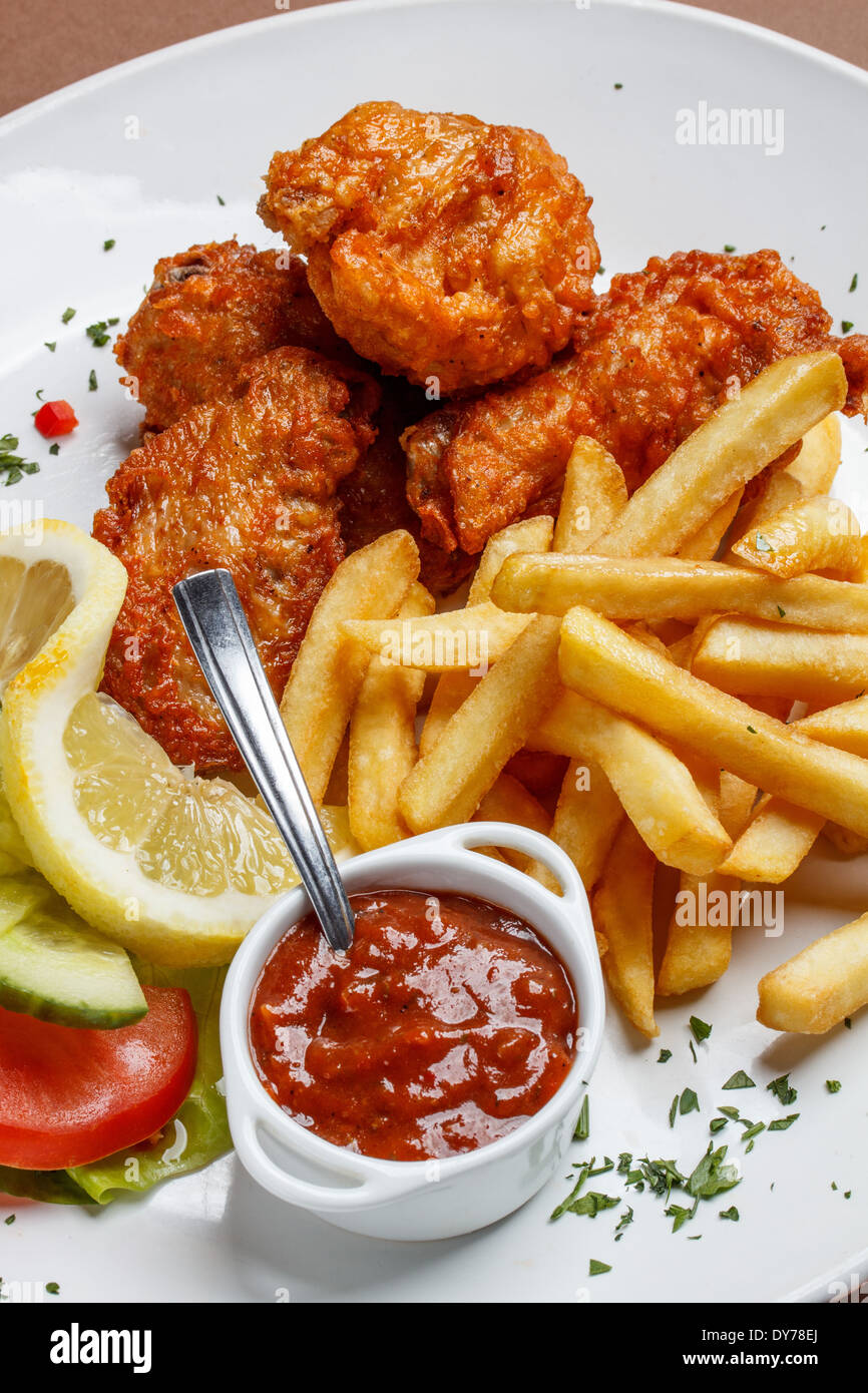 Gebratene Hähnchenschenkel mit Pommes frites Stockfoto