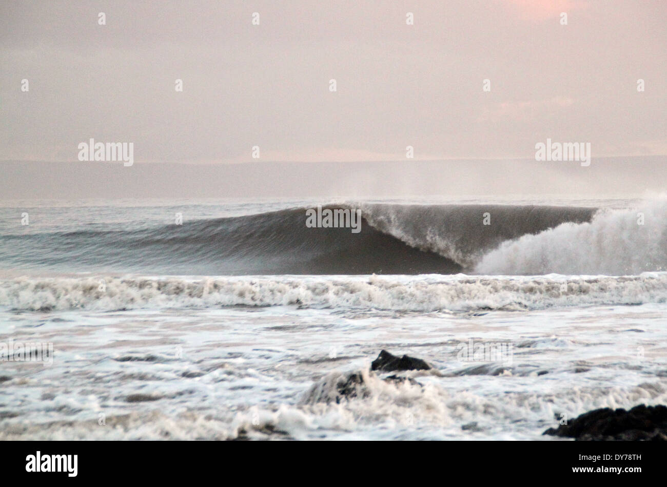 Kalten Winterwellen brechen in Coney Strand Porthcawl Südwales mit ablandigem Wind Stockfoto