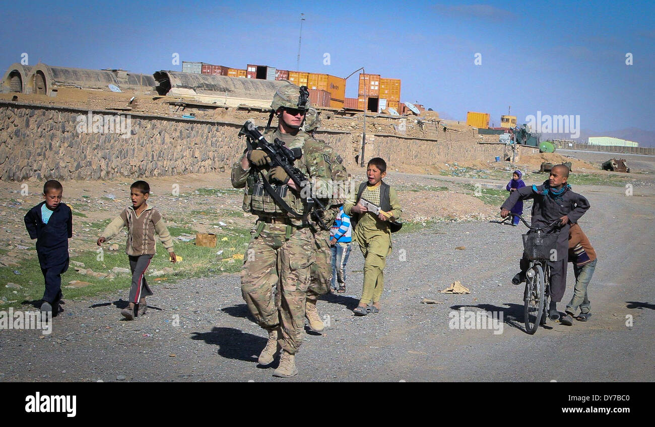 Ein US-Soldat geht seiner Patrouille mit afghanischen Kindern während einer Patrouille Dorf 24. März 2014 in der Provinz Kandahar, Afghanistan. Stockfoto