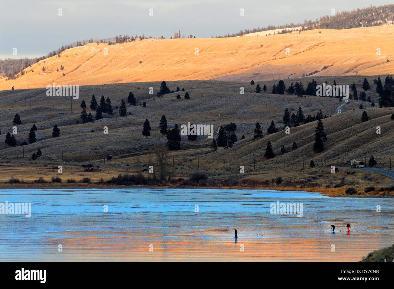 41,674.04239 drei 3 Männer Eisfischen auf glatten blauen Eis bedeckt gefrorenen See Nicola "kein Schnee" "schneefrei" Sonnenuntergang Hügellandschaft Stockfoto