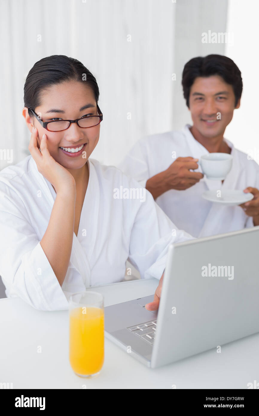 Paar im Bademantel, die er am Morgen zusammen mit laptop Stockfoto