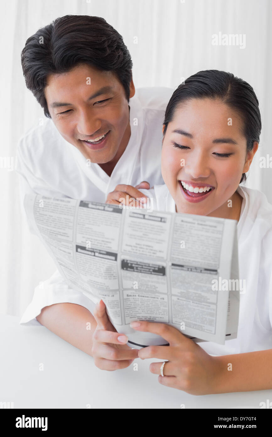 Paar im Bademantel lesen Zeitung zusammen am Morgen Stockfoto