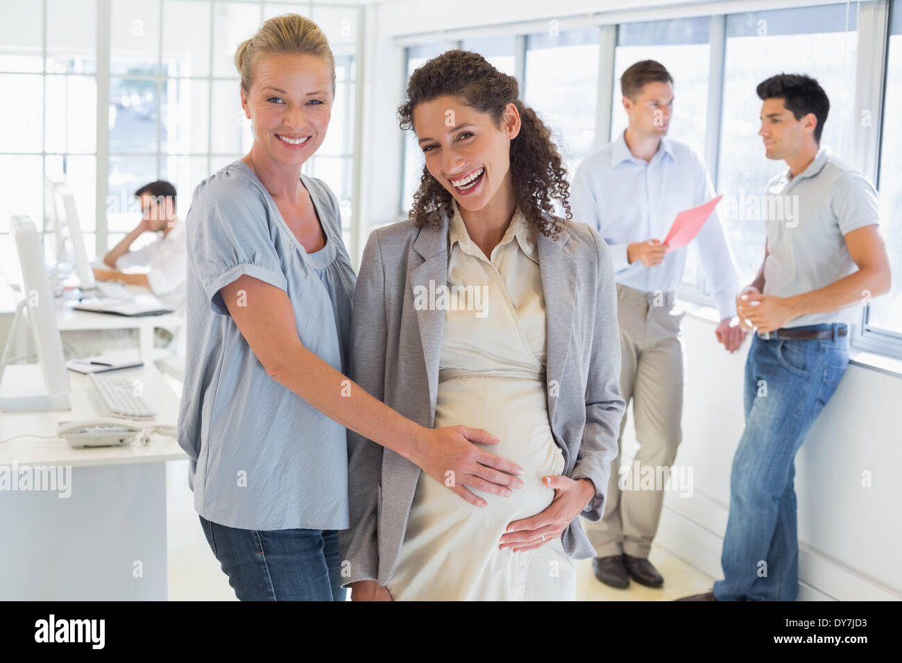 Lässige Geschäftsfrau berühren Bauch schwanger Kollegen Stockfoto