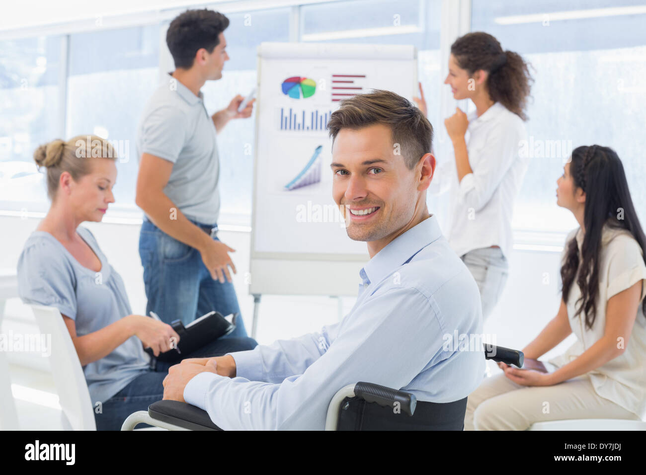 Lässige Geschäftsmann im Rollstuhl lächelnd in die Kamera während der Präsentation Stockfoto