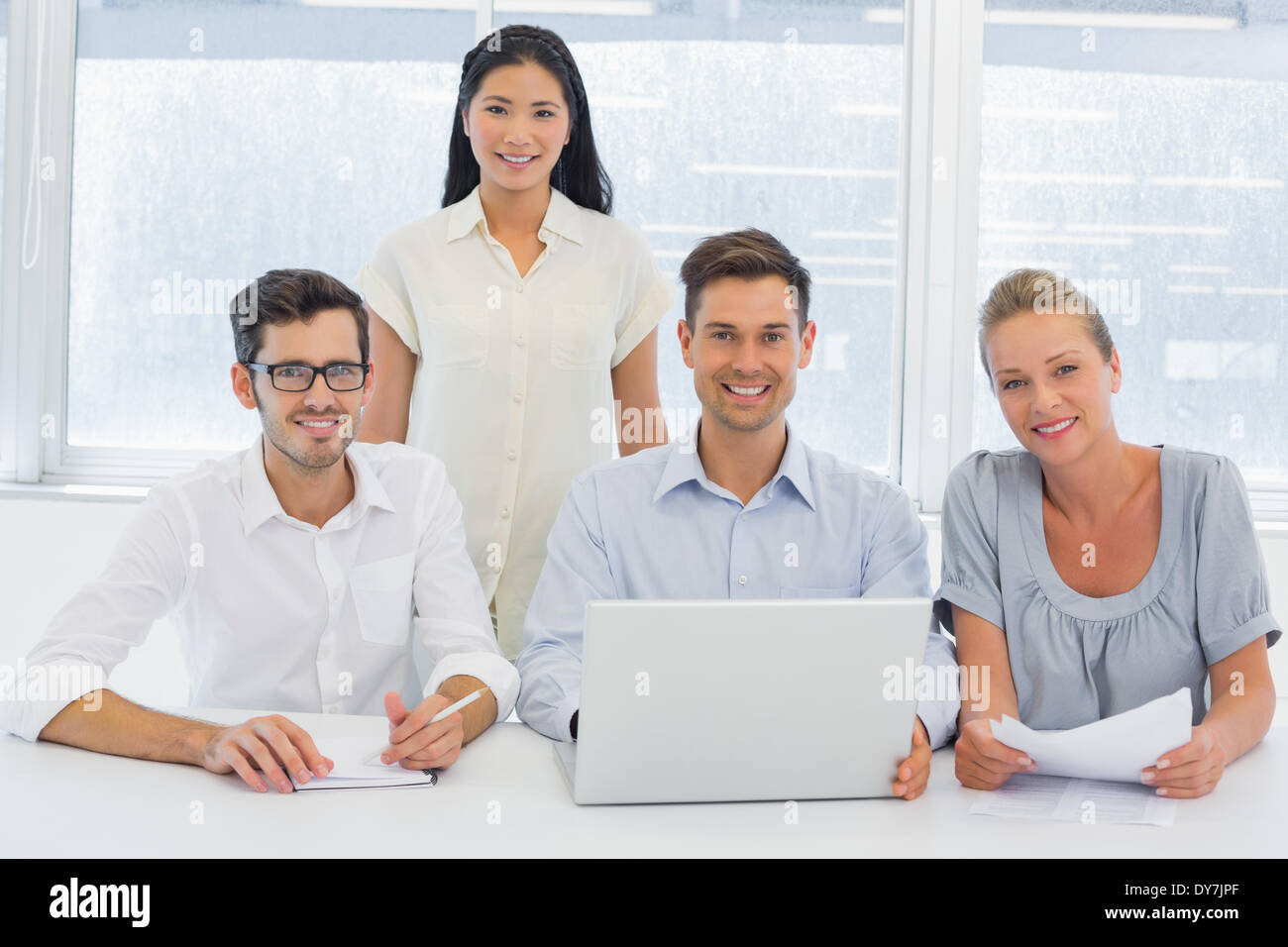 Casual Business-Team gemeinsam an Rezeption lächelnd in die Kamera Stockfoto