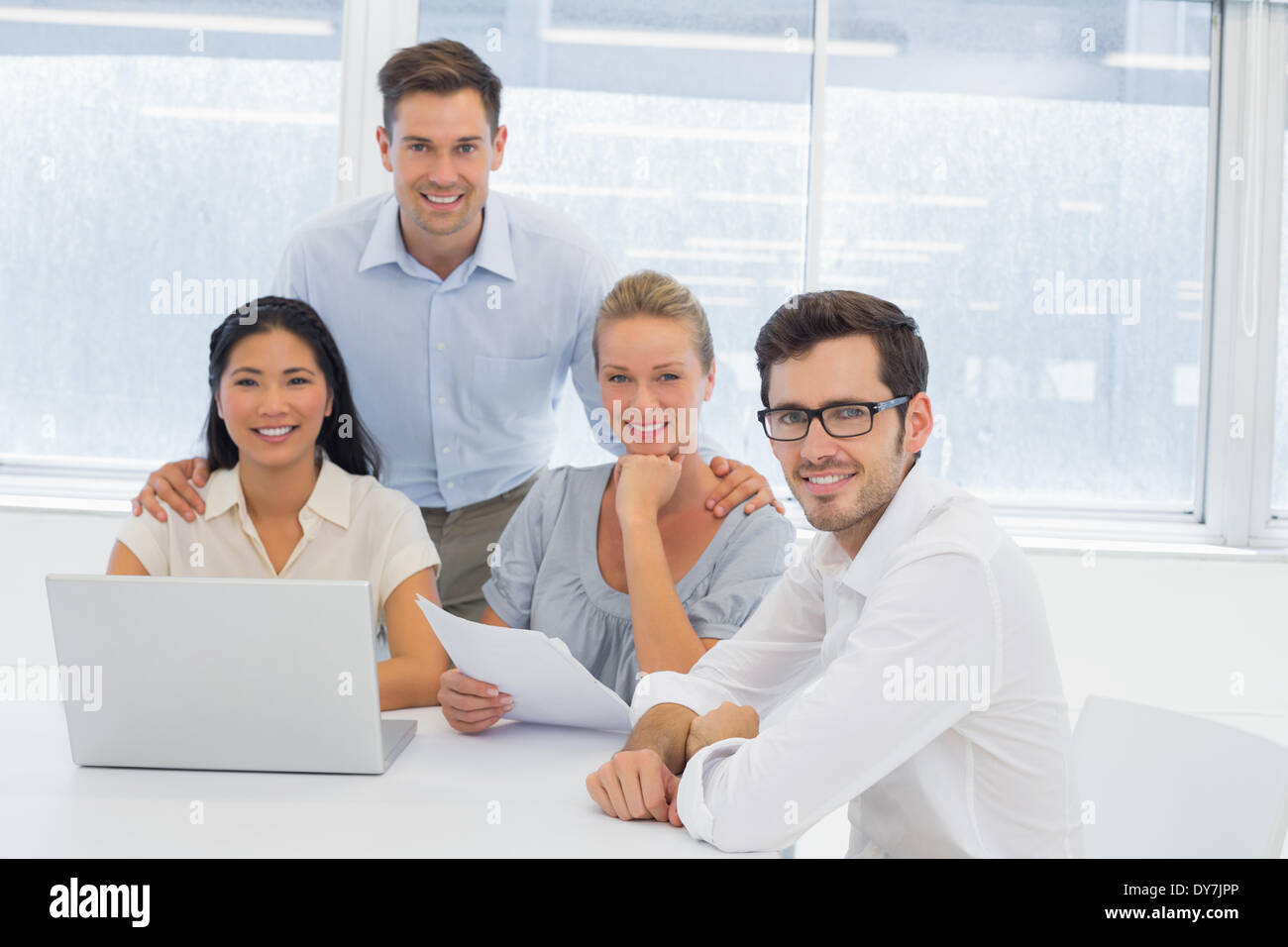 Casual Business-Team gemeinsam an Rezeption lächelnd in die Kamera Stockfoto