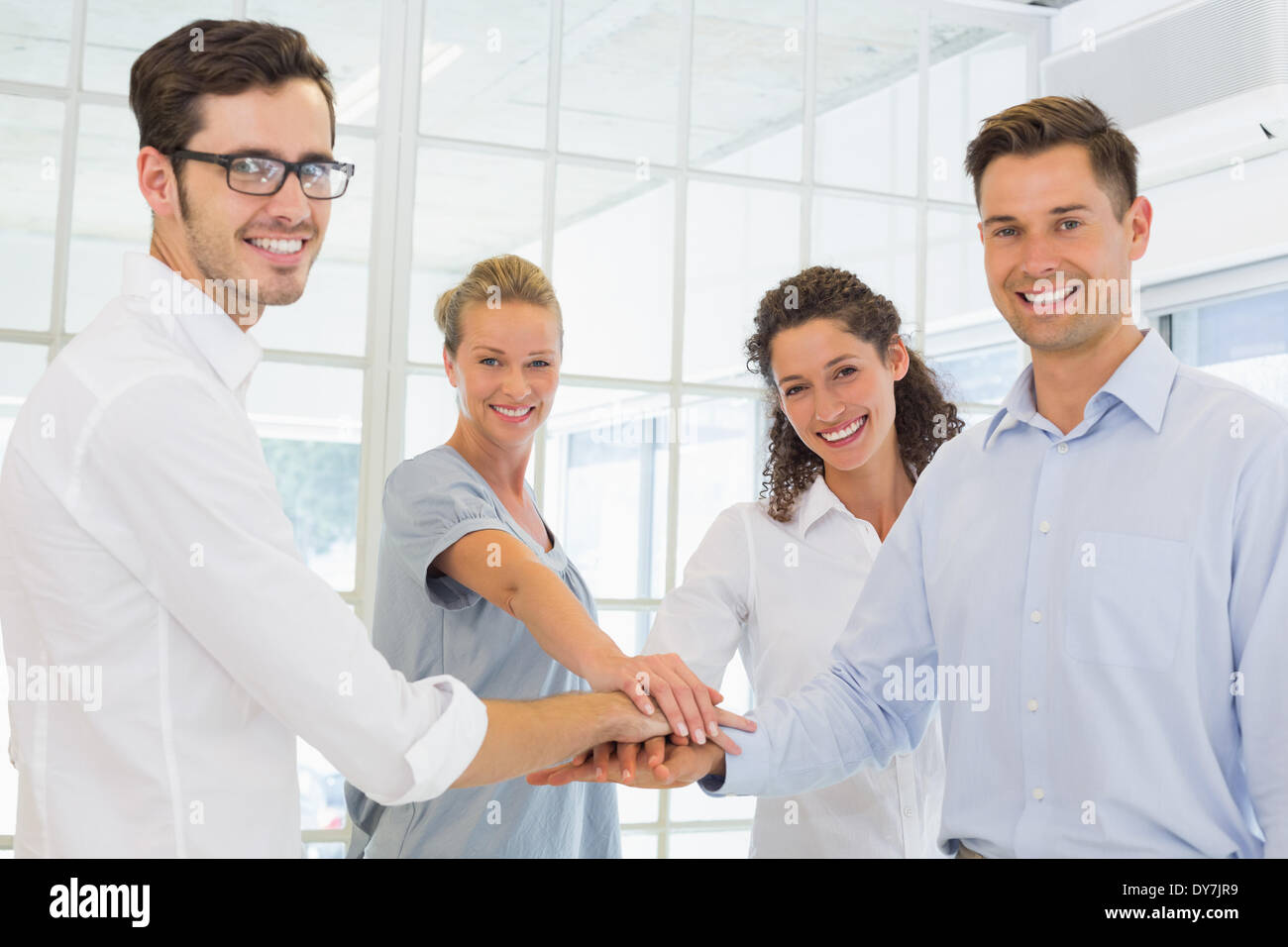 Lässig lächelnd Business-Team setzen ihre Hände zusammen Stockfoto