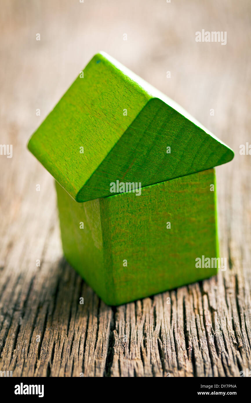 Grüne Haus aus hölzernen Würfel auf hölzernen Hintergrund Stockfoto