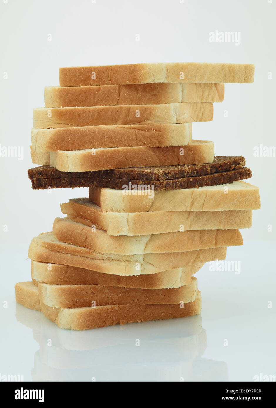 Scheibe Schwarzbrot in einem Stapel von Toast-Brot Stockfoto