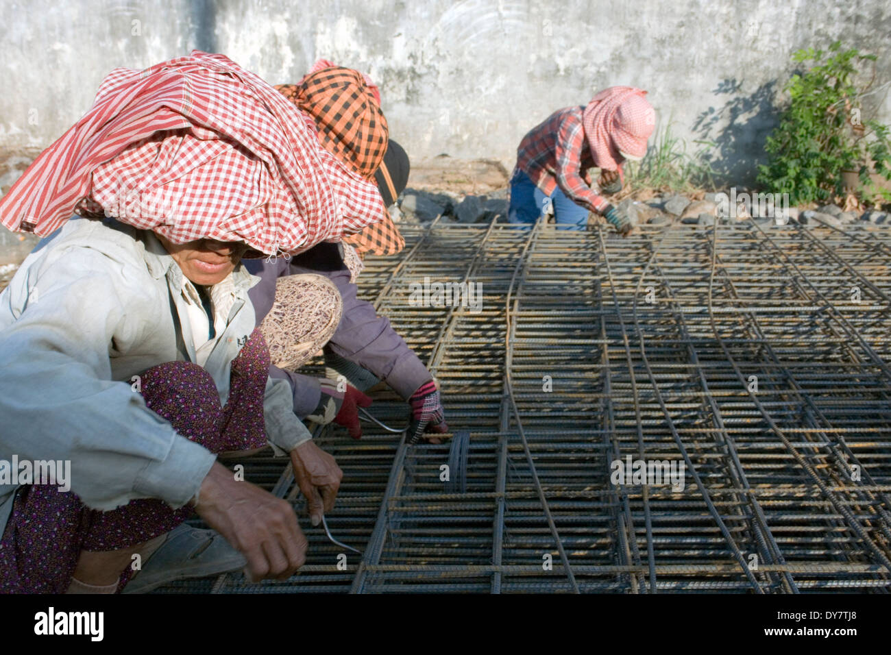 Arbeitnehmerinnen in Eisen machen einen Rahmen mit Metall auf eine Stadt Straße in Kampong Cham, Kambodscha. Stockfoto