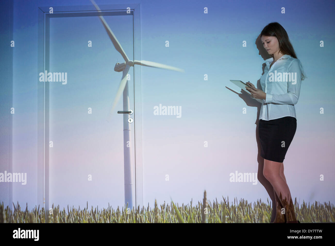 Junge Frau mit Projektion der Windturbine mit digital-Tablette Stockfoto