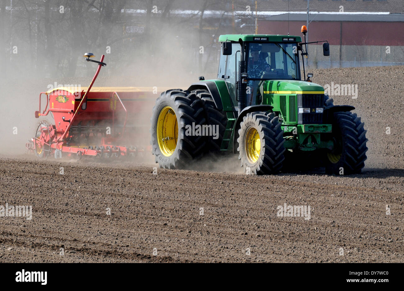 Traktor mit Sämaschine arbeitet auf staubigen Feldern im Frühjahr Landwirtschaft. Köpingebro, Scania, Schweden Stockfoto