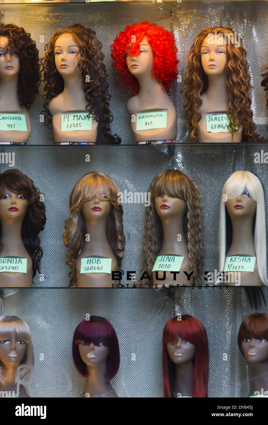 Reihen von weiblichen Perücken auf Schaufensterpuppe Kopf in einem Schaufenster Stockfoto