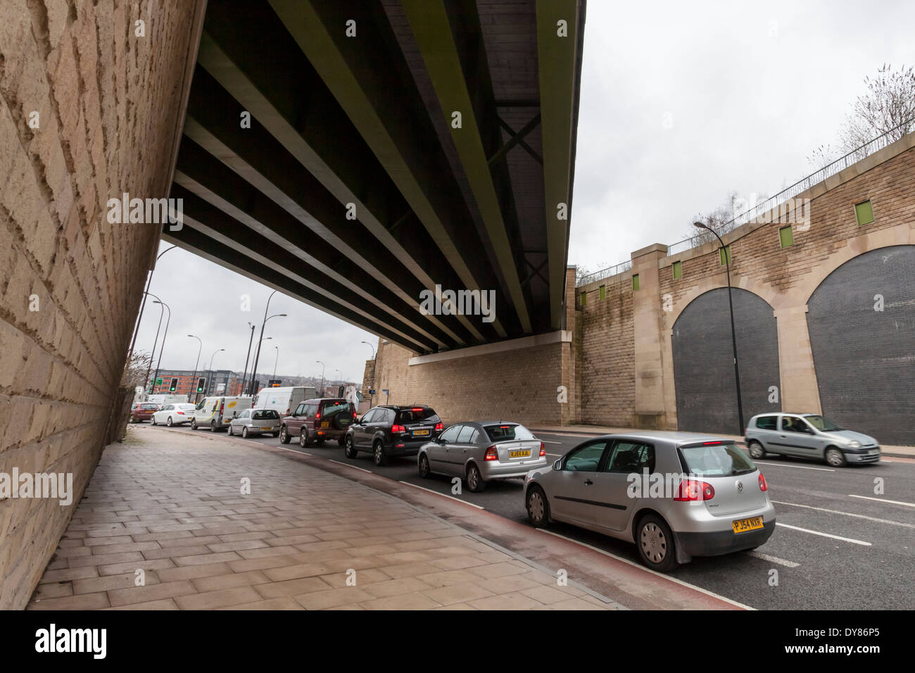 Queueing Verkehr auf einer Straße unter einer Brücke, Sheffield, England, UK Stockfoto