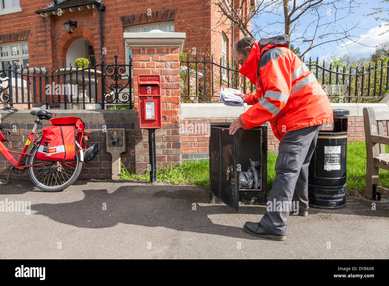 Royal Mail Briefträger sammeln Post für die Lieferung auf seinem Fahrrad im Dorf von Plumtree, Nottinghamshire, England, Großbritannien bereit Stockfoto