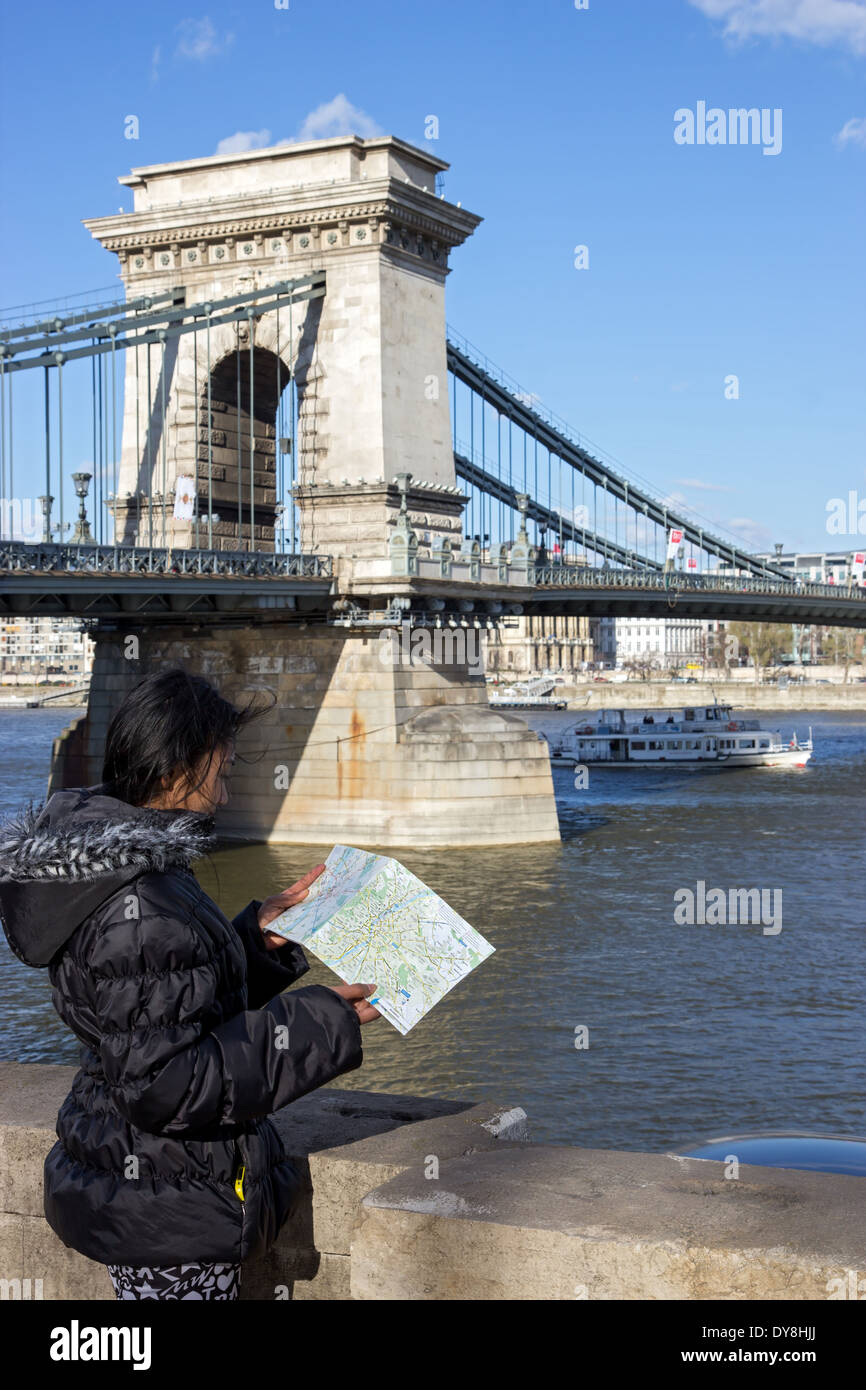 Eine Frau sieht im Stadtplan an der Kettenbrücke Stockfoto