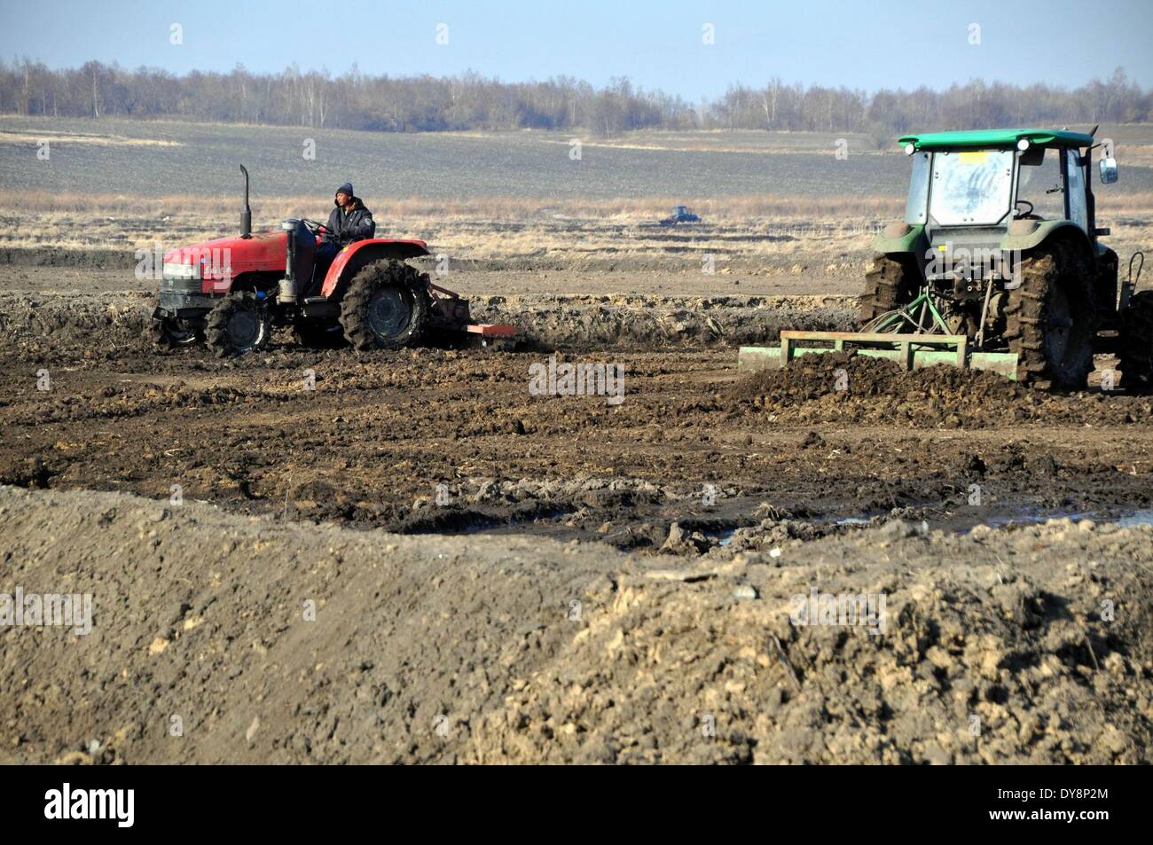 Heihe, Chinas Provinz Heilongjiang. 9. April 2014. Menschen arbeiten auf einem Bauernhof in Heilongjiang Reclamation Area in Heihe, Nordost-China Provinz Heilongjiang, 9. April 2014. Heilongjiang Reclamation Area, auf einer Fläche von etwa 2,4 Millionen Hektar, ist die größte staatliche Farm und auch die wichtige Basis der marktfähigen Korn in China. © Zhou Liangjun/Xinhua/Alamy Live-Nachrichten Stockfoto