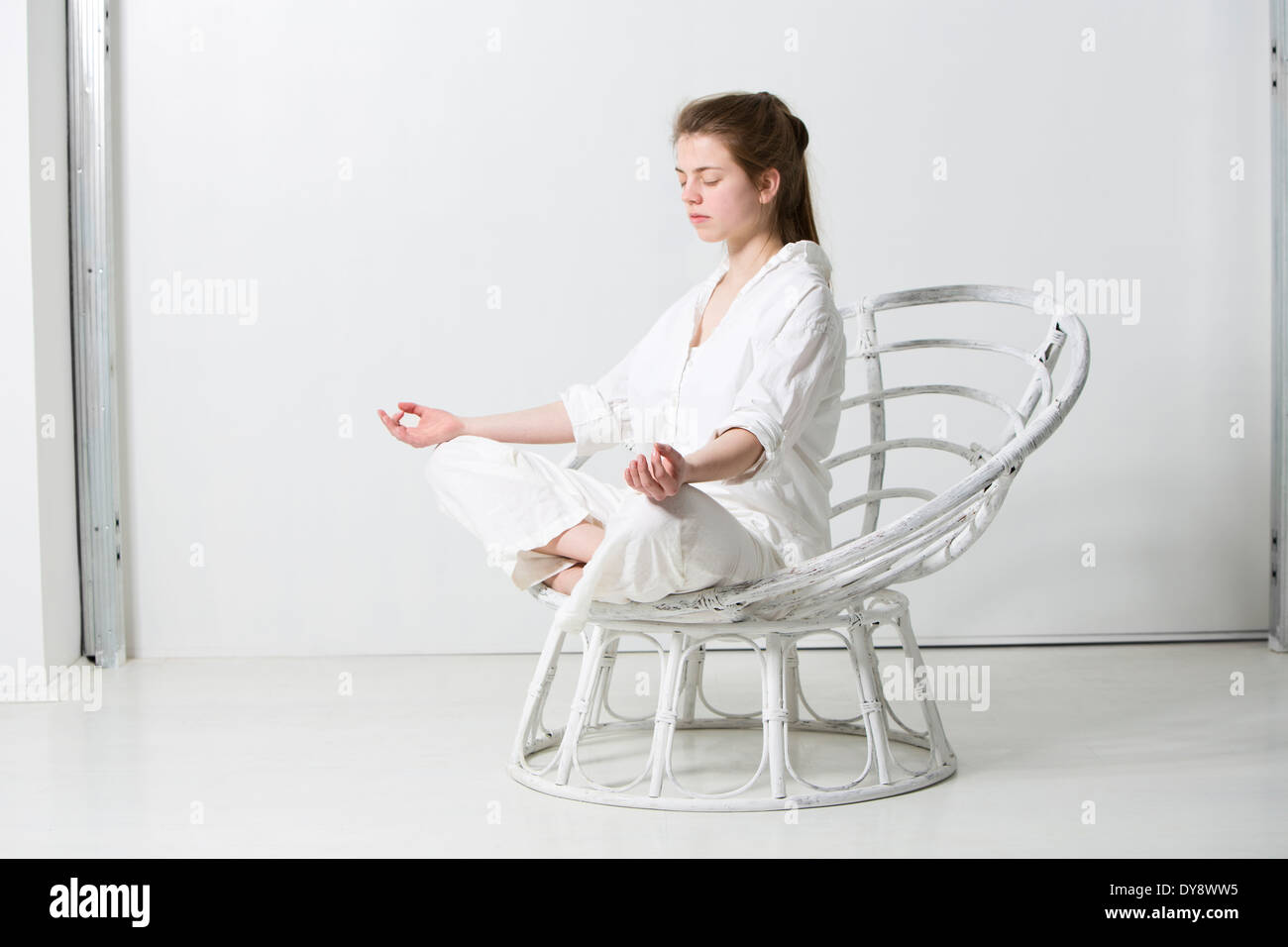 Teenager-Mädchen trainieren Yoge Position im weißen Raum Stockfoto