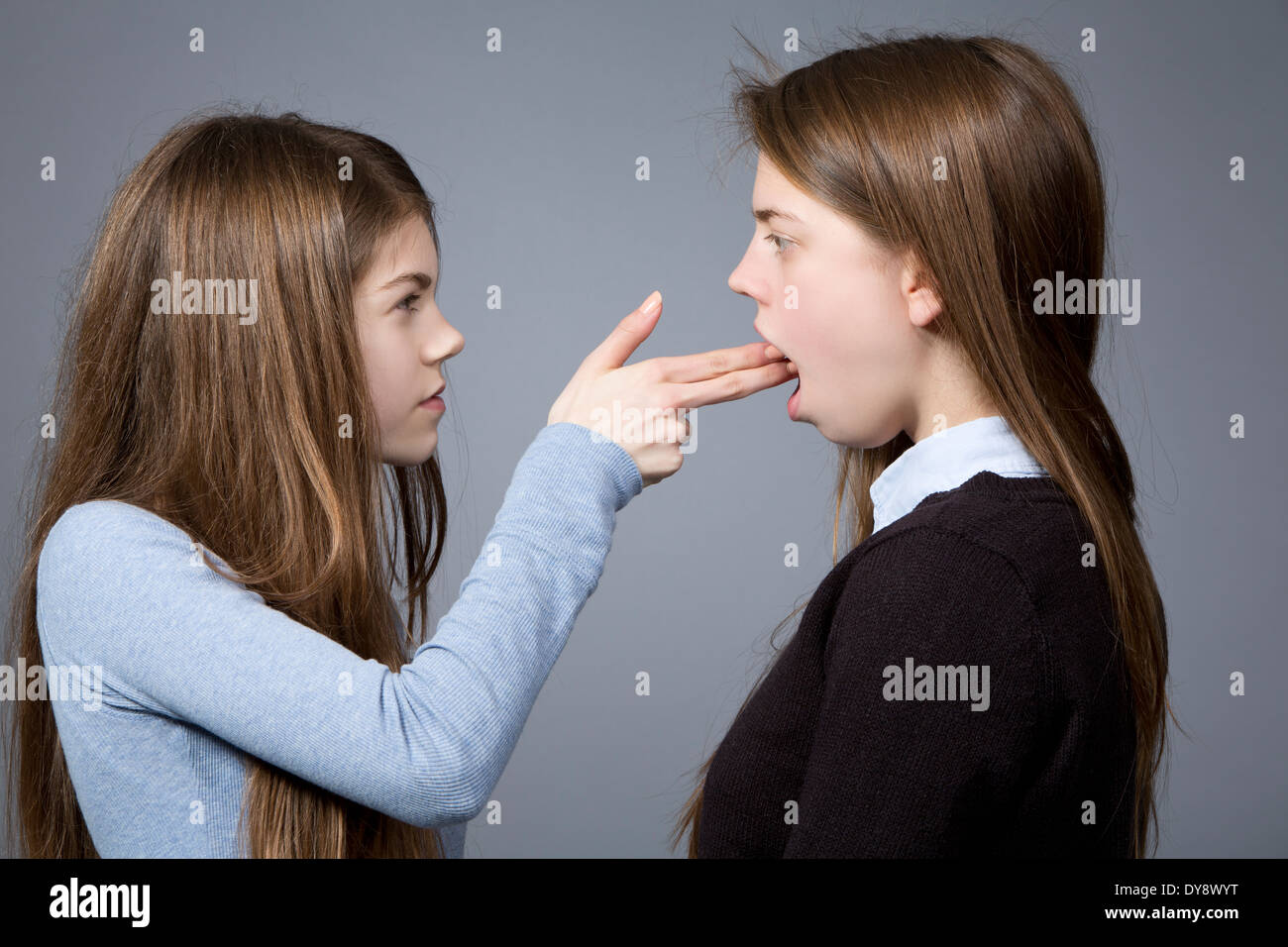 Teenager-Mädchen machen Pistole Zeichen gegen ihre Schwester Stockfoto