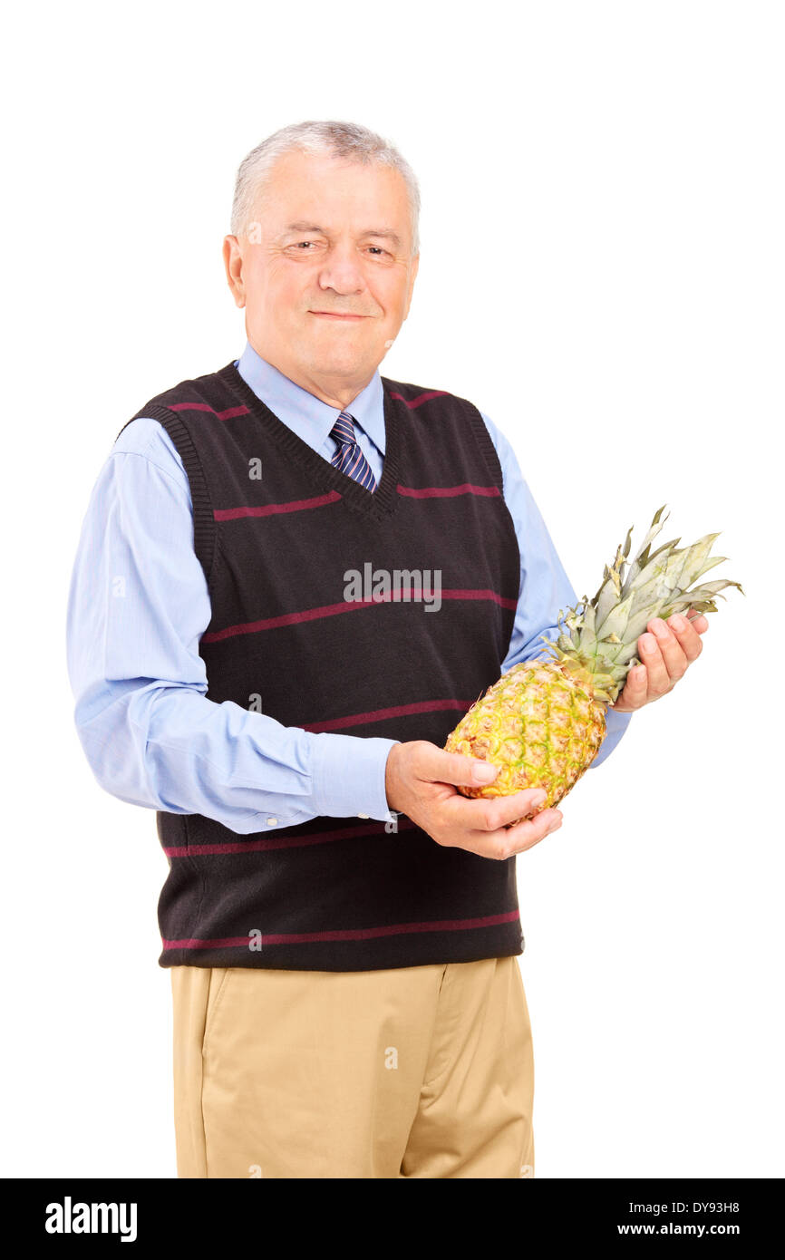 Reifer Mann hält eine Ananas Stockfoto