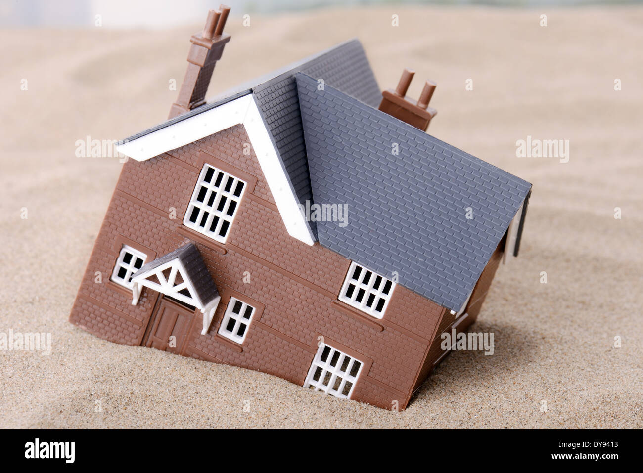 Ein Haus im Sand, Konzept für Wohnungsprobleme zu versinken Stockfoto