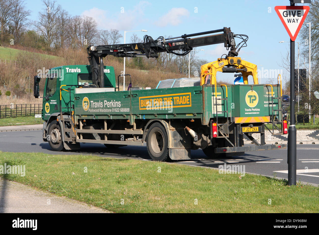 Travis Perkins greifen LKW Reisen rund um einen Kreisverkehr in Coulsdon, Surrey, England Stockfoto