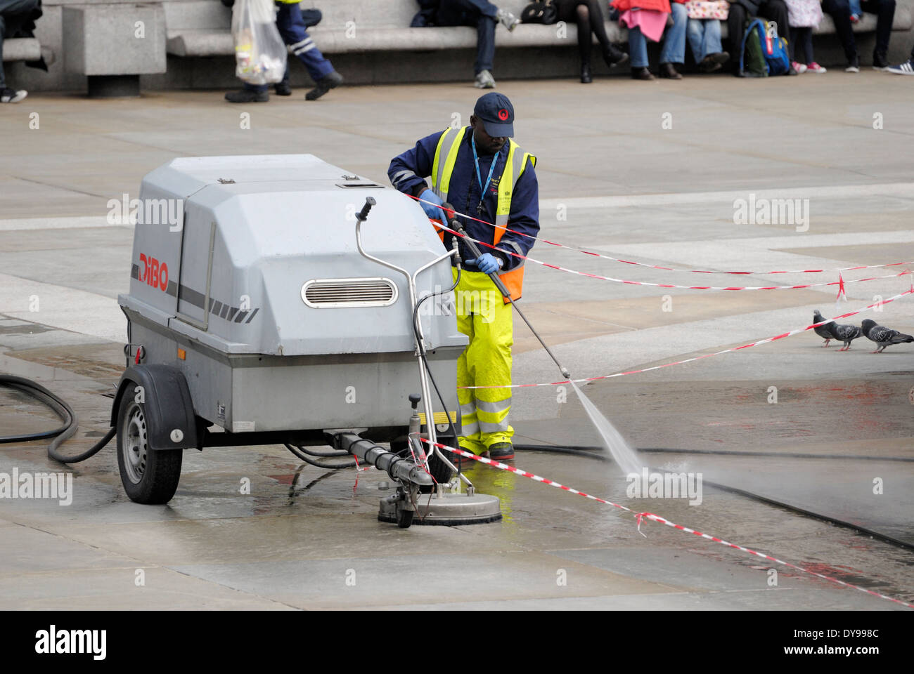 London, England, Vereinigtes Königreich. Arbeiter, die Reinigung von Trafalgar Square mit Hochdruck-Wasserschlauch Stockfoto