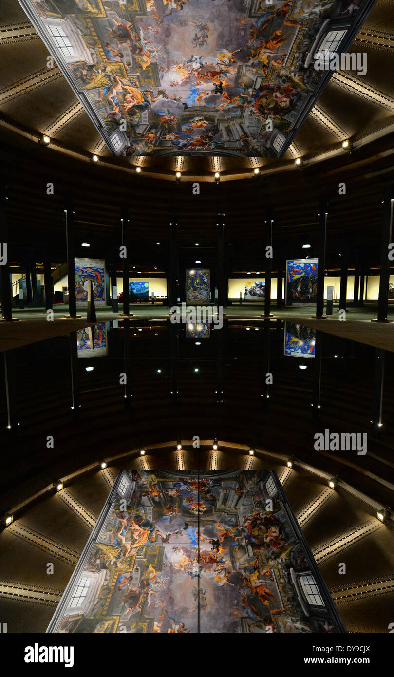 Oberhausen, Deutschland. 10. April 2014. Ein Bild von dem Deckenfresko 'Apotheose des Heiligen Ignatius' spiegelt sich auf einer Glasscheibe im Gasometer, einem ehemaligen Gasspeicher in Oberhausen, Deutschland, 10. April 2014. Im Vordergrund: Bilder von "Das Urteil von Paris" (L) von Lucas Cranach der ältere und das Ölgemälde "Porträt einer Negerin" von Marie-Guillemine Benoist. Die Ausstellung "The Aussehen of Beauty" läuft vom 11. April bis 30. Dezember 2014 und zeigt mehr als 150 Fotografien oder Abgüsse von bedeutenden Kunstwerken aus verschiedenen Epochen. Foto: Matthias Balk/Dpa/Alamy Live News Stockfoto