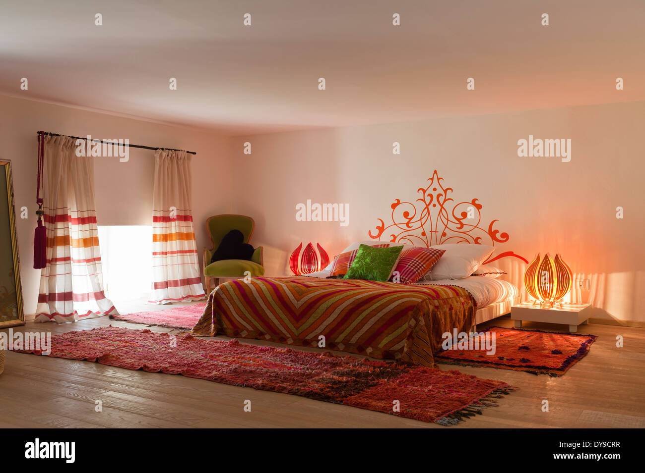 Bunte Stoffe auf Metall Bett mit Zwiebel Stil Lampen Stockfoto