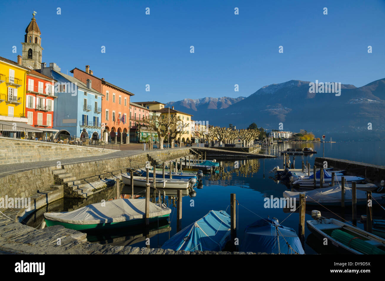Alpendorf Ascona mit blauen Himmel und Berge und einen kleinen Hafen mit Booten in der Tessiner Schweiz, Europa, Stockfoto