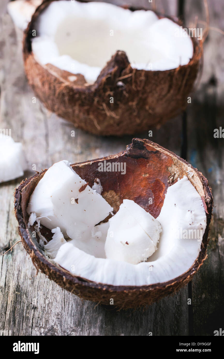 Zerbrochene Kokosnussschalen auf alten hölzernen Hintergrund Stockfoto