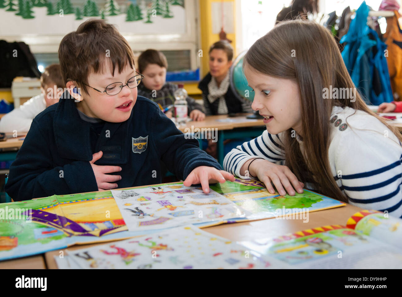 Nicht behinderte und behinderte Schüler (in diesem Fall ein Junge mit Down-Syndrom) lernen gemeinsam in der gleichen Klasse. Stockfoto