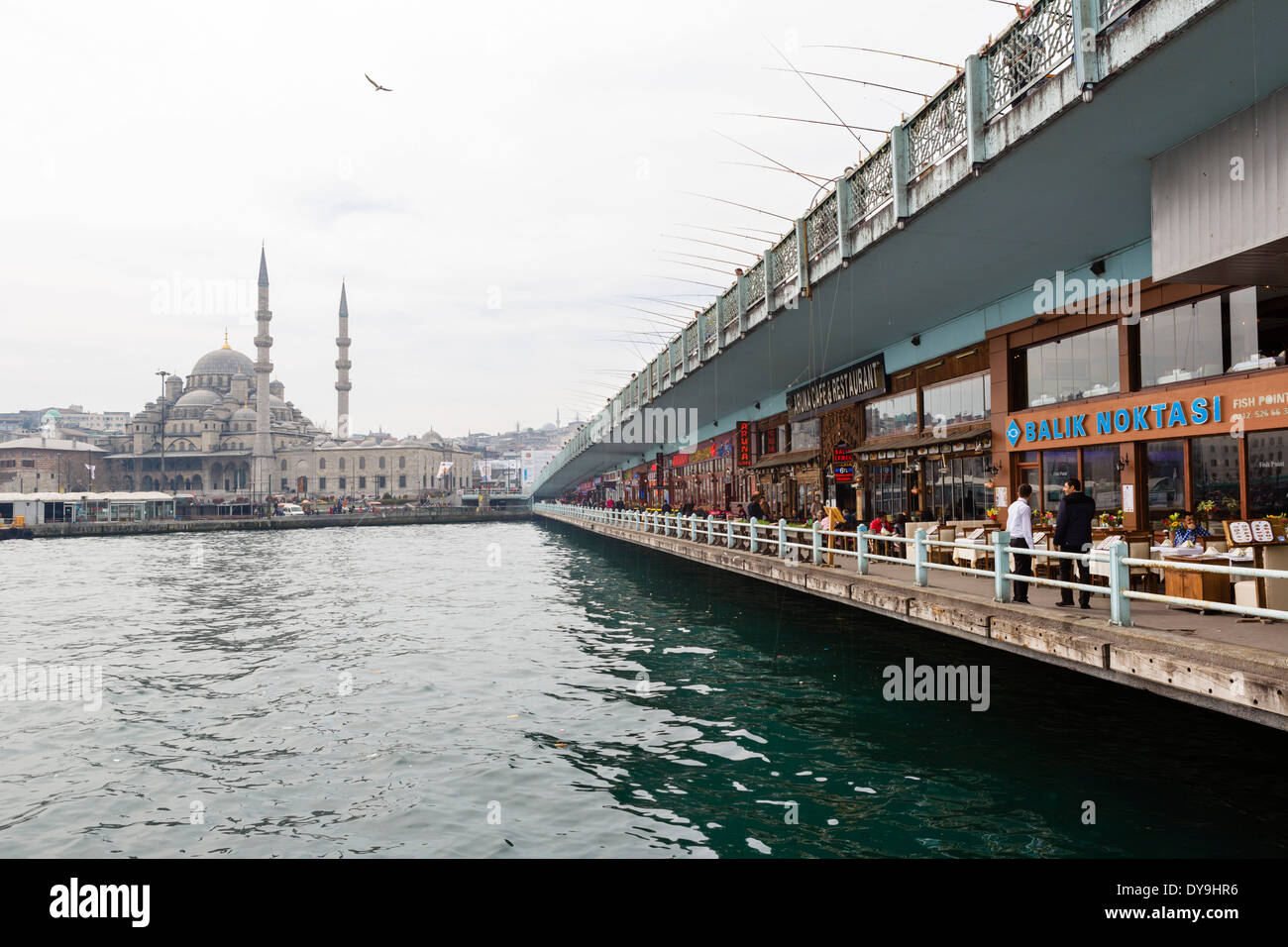 Fisch-Restaurants unter der Galata-Brücke über das Goldene Horn mit neuen Moschee (Yeni Camii) hinter Viertel Eminonu, Istanbul, Türkei Stockfoto