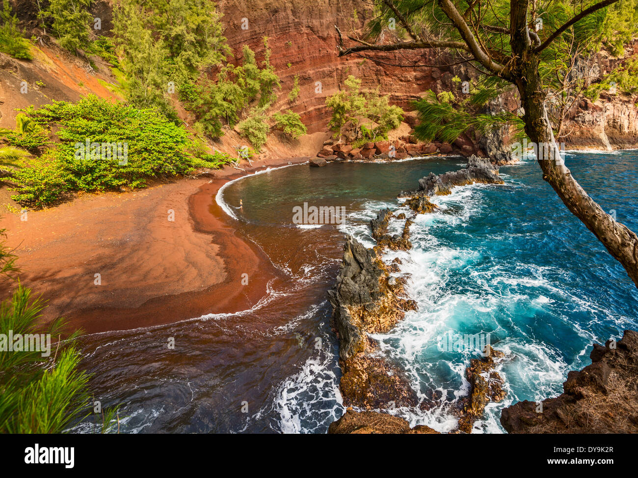 Eine Frau genießen Sie die exotische und atemberaubende Red Sand Beach auf der hawaiianischen Insel Maui. Stockfoto