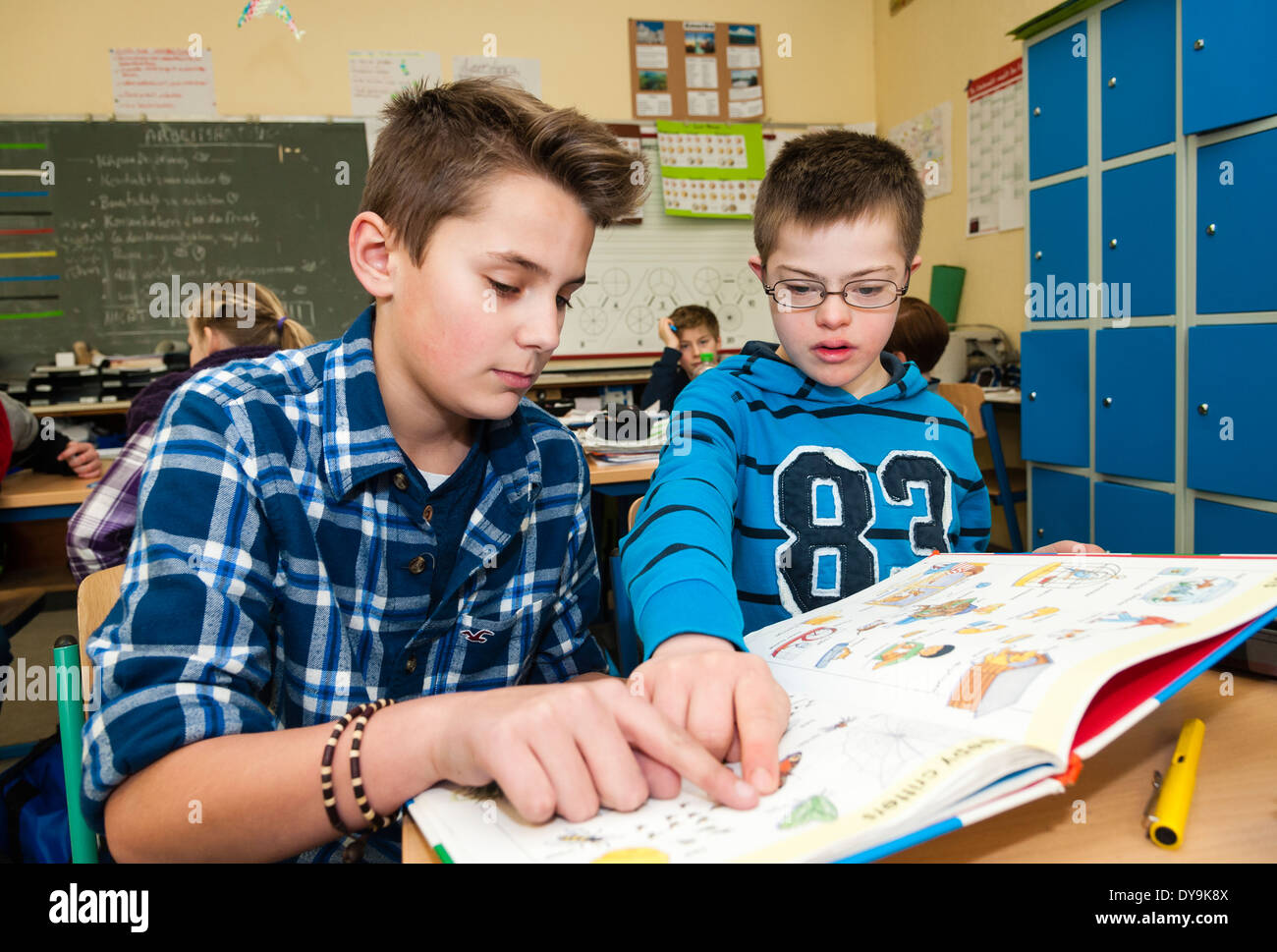 Nicht behinderte und behinderte Schüler (in diesem Fall ein Junge mit Down-Syndrom) lernen gemeinsam in der gleichen Klasse. Stockfoto