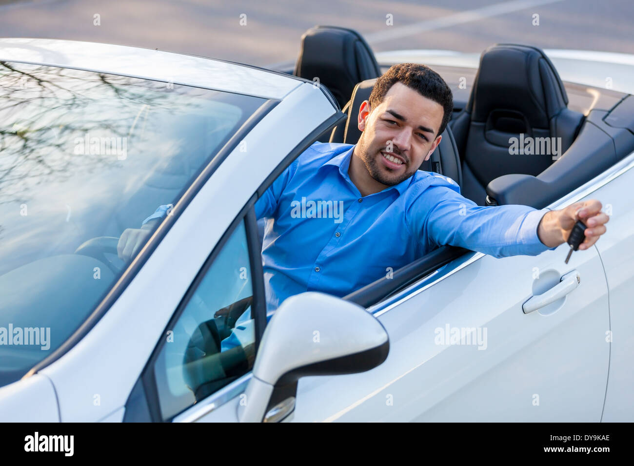 Junge schwarze lateinamerikanischen Fahrer hält mit seinem neuen Auto Autoschlüssel Stockfoto