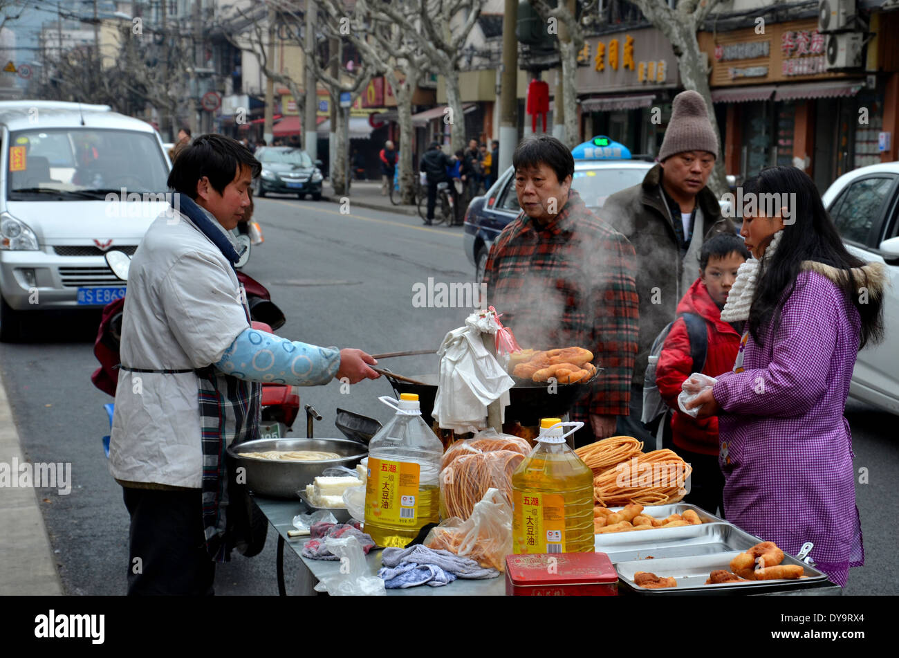 Streetfood Stall Koch bereitet frittierte Speisen auf mobilen Stall mit wartenden Kunden Shanghai China Stockfoto
