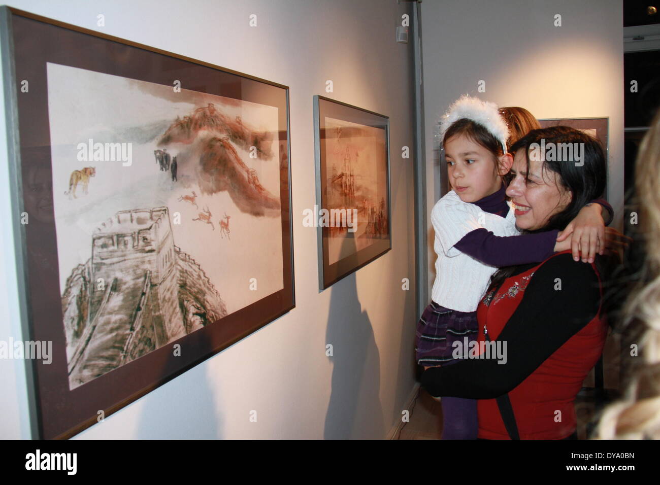 (140411)--LJUBLJANA, 11. April 2014 (Xinhua)--eine Mutter und ein Kind besuchen Gemälde von Wang Huiqin, chinesischer Maler Leben in Slowenien, während einer Zeremonie in Ljubljana/Slowenien, 10. April 2014. Wangs neue Comic-Buch mit alten slowenischen Astronomen Ferdinand Avgustin Hallerstein startete hier am Donnerstag, die als Förderer für den kulturellen Austausch zwischen China und Slowenien gefeiert wird. Hallerstein (1703 – 1774), ist mit einem chinesischen Namen Liu Song Ling, eine legendäre Person bekannt für seinen großen wissenschaftlichen Beitrag während seiner 31 jährige Dienstzeit als Chef des kaiserlichen Astronomen an der th Stockfoto