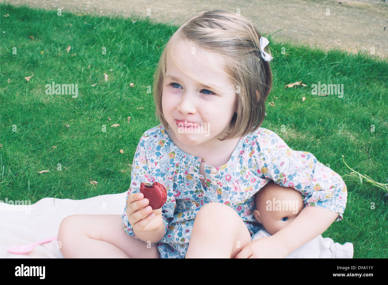 Kleine Mädchen essen Makronen Stockfoto