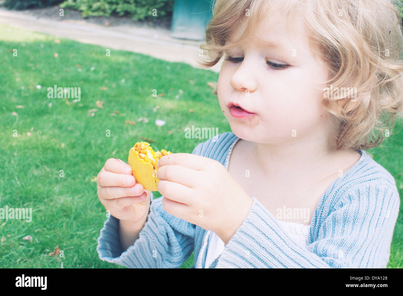 Kleine Mädchen essen Makronen Stockfoto