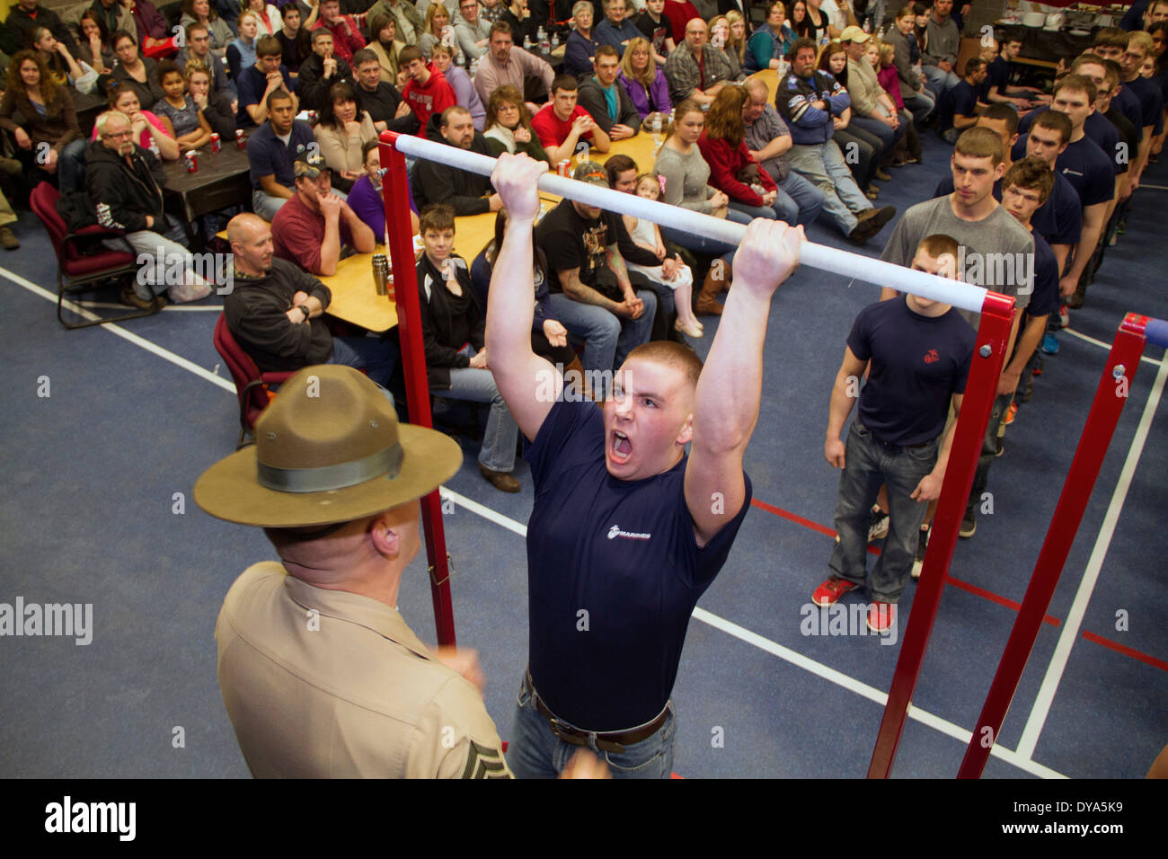 Morgan Daly, ein Marine-Poolee ist durch seine Drill Instructor motiviert, wie er Klimmzüge während einer Teilprüfung der ersten Stärke führt, wie Eltern 3. April 2014 in Green Bay, Wisconsin beobachten. Stockfoto
