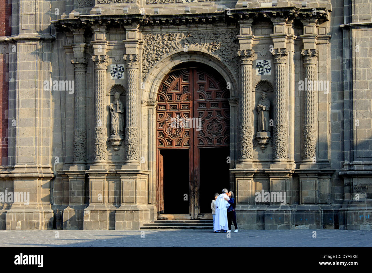 Priester und Mensch vor der großen Tür der Kirche in der Plaza de Santo Domingo, Centro Historico, Mexiko-Stadt Stockfoto