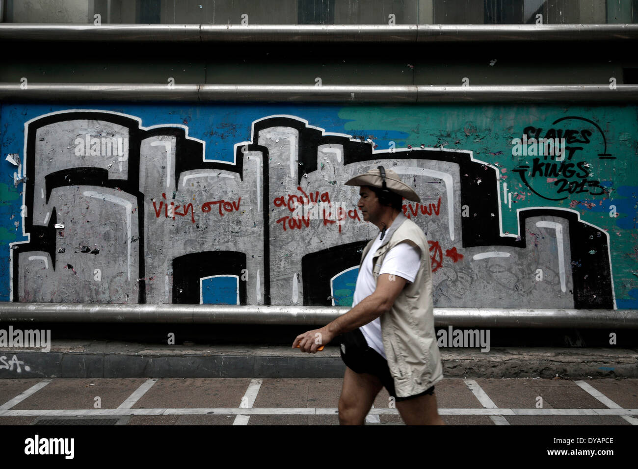 Athen, Griechenland. 11. April 2014. Ein Mann geht vorbei ein Graffiti, das "Sieg im Kampf der Gefangenen" in Athen am 11. April 2014 liest. Bildnachweis: Konstantinos Tsakalidis/Alamy Live-Nachrichten Stockfoto