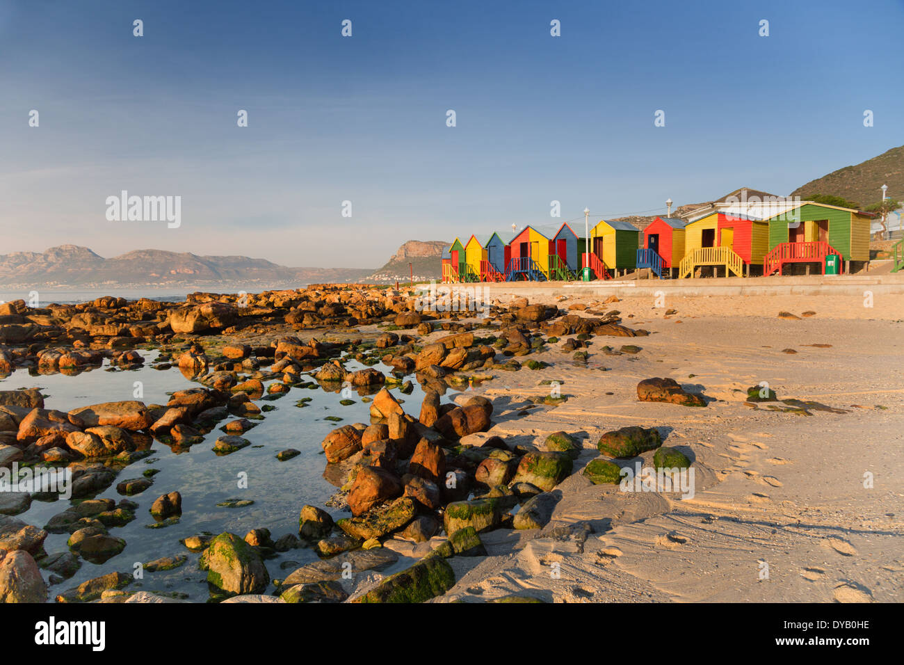 Landschaft Foto des berühmten roten, gelben, grünen und blauen bunte Strandhütten an St James' Beach Kapstadt, Felsen und Strand Stockfoto