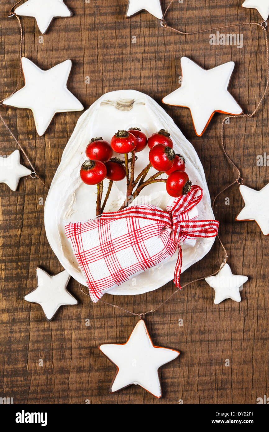 Maritime Dekoration mit Sternen, Geschenktüte, Hagebutten, weihnachtlich Stockfoto
